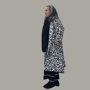 Seitenansicht von einer Frau mit grauen Haaren die einen Strickmantel trägt-